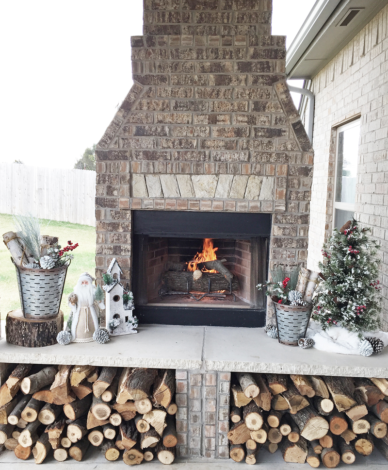 Outdoor fireplace wood storage idea and design idea. Featuring a rustic christmas decorations idea.