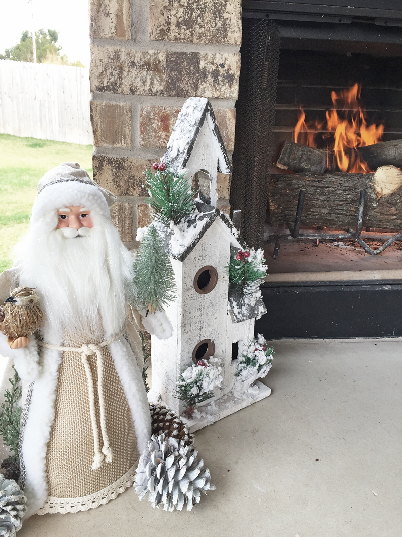Santa Tree Topper and Church Christmas decorations for an outdoor fireplace and patio.