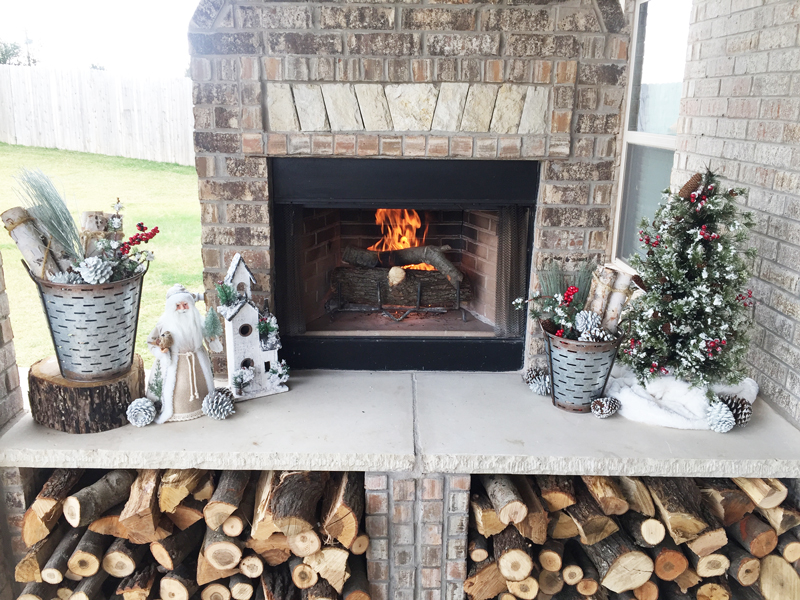 Rustic Christmas Decorations on an outdoor fireplace. Outdoor Christmas Patio and porch decoration ideas.